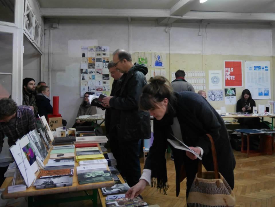 Girl picking up a publication from a book stand