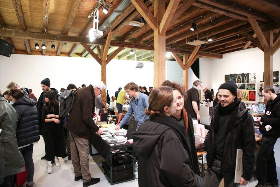 A room full with people and book stands