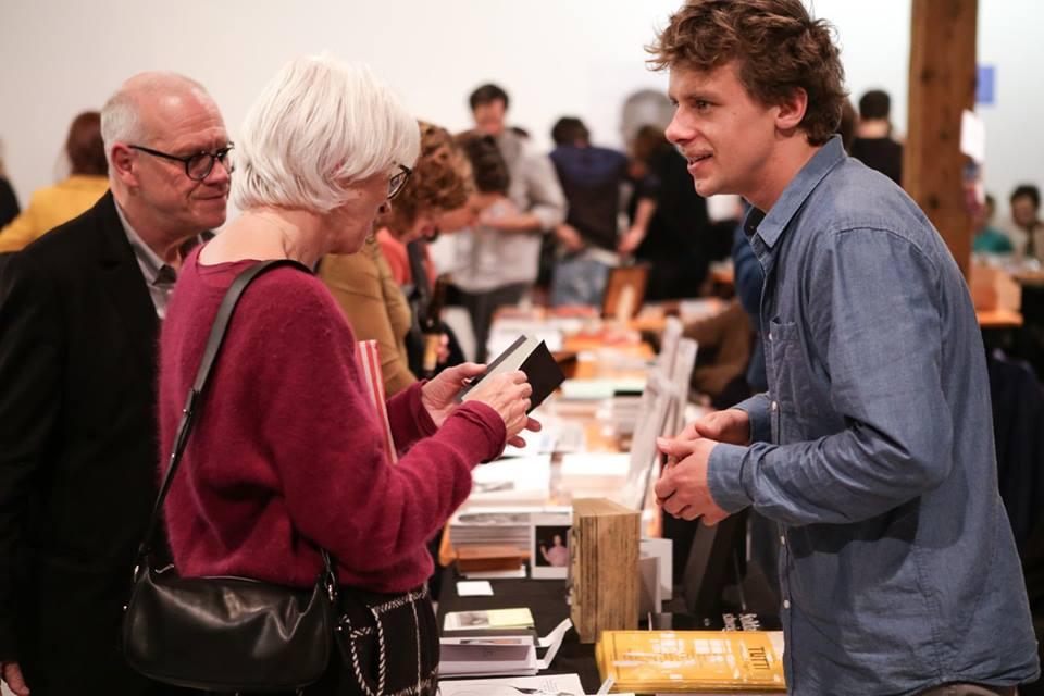 A guy explaining a book to a coupe