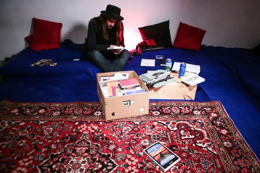 © ALF Guy sitting on a carpet with a box of books