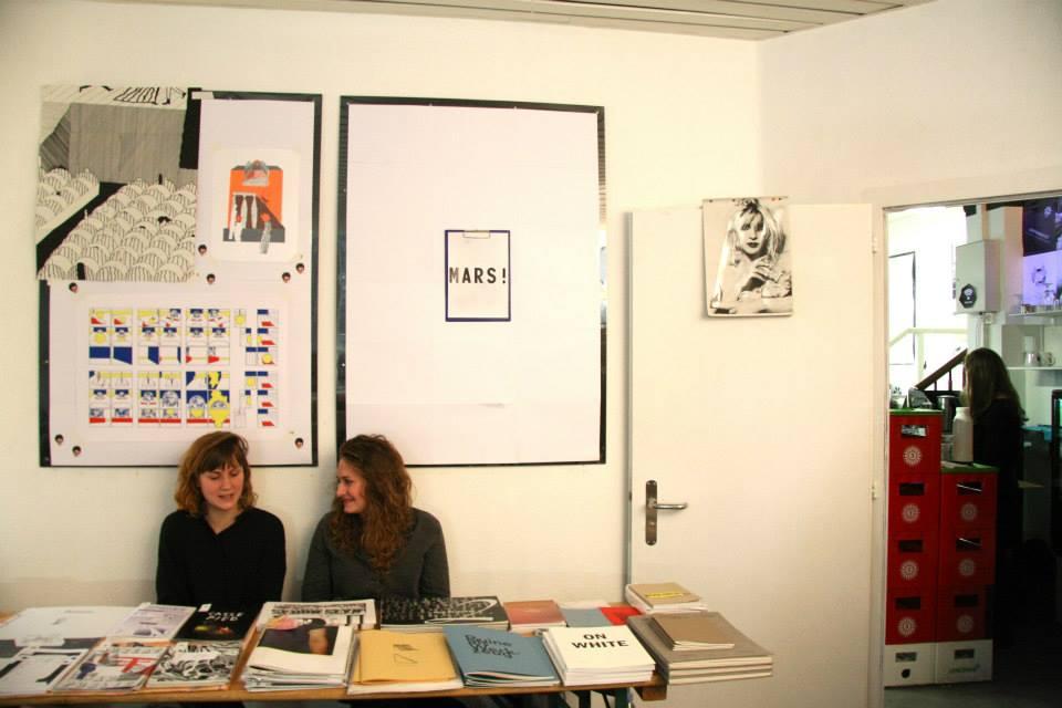 © ALF Two people sitting behind a book stand